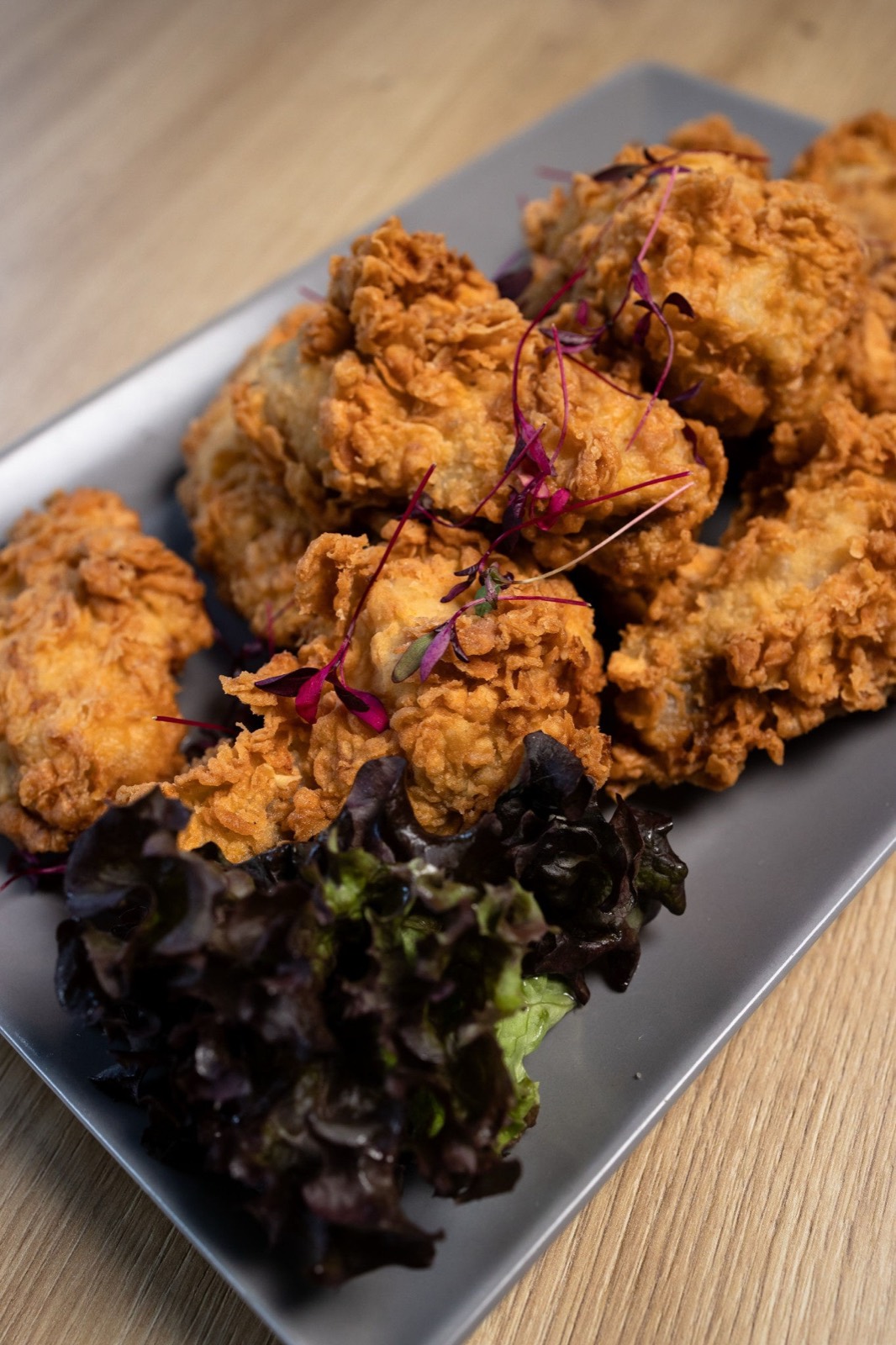 Crunchy bundás csirkefalatok tálon, friss salátával