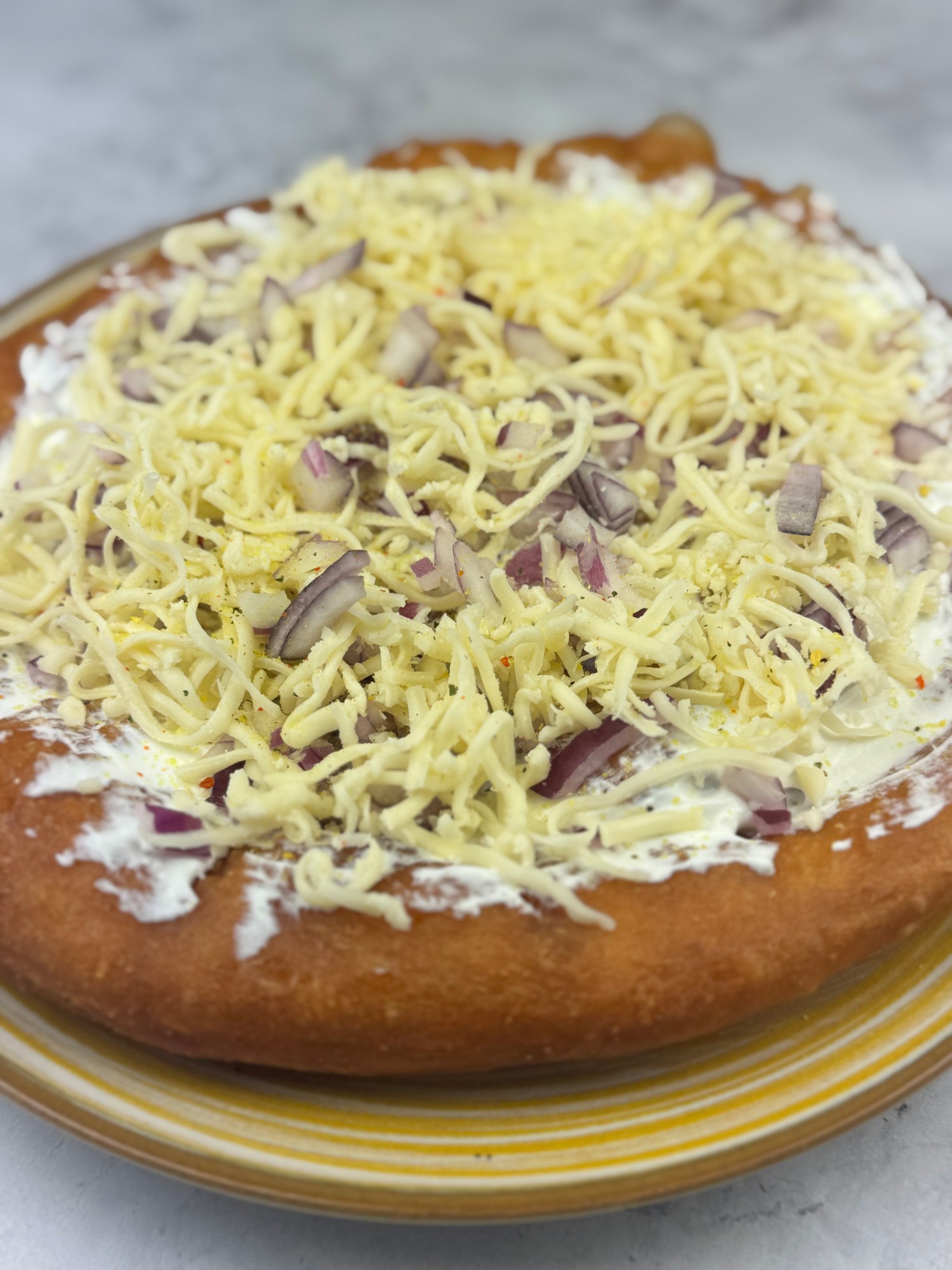 Tejfölös-sajtos lángos lilahagymával